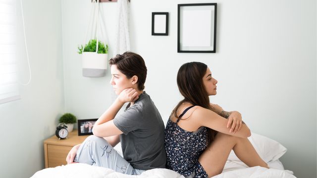 Ilustración de una pareja sentada en el sofá, cada uno mirando a un lado